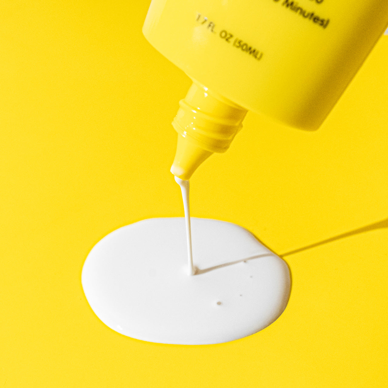 (S)undercover bottle close up with product coming out on yellow background